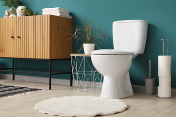 Interior of restroom with toilet bowl, commode and table