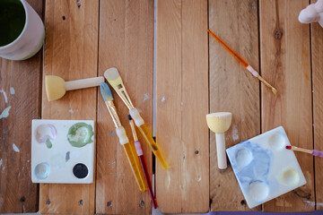 Many colorful painter brushes on a pot and cleaning on water and sponges