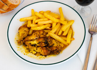 Savory chicken wings stew with vegetable sauce and french fries.