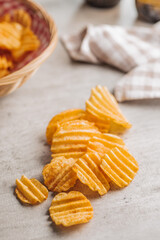 Crispy potato chips on kitchen table.