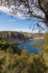Naklejka premium Scenic Bay View with Sailboats and Cliffs