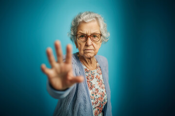 Elderly woman in floral blouse and cardigan extends her hand forward, symbolizing a call for awareness and action against elder abuse. Blue background enhances the message of dignity and respect for s