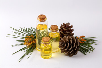 Pine turpentine essential oil in glass bottle with pine coniferous leaves and pine cone. Kiefer...
