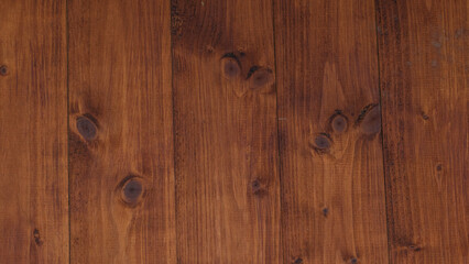 Close-up view of a dark wooden panel featuring unique knots and a rich, deep brown texture that enhances its natural and sophisticated appearance