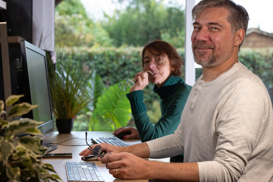 deux coll&egrave;gues travaillent ensemble au bureau. Un homme et une femme zen et souriants