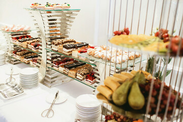 Wedding cake table background. Sweet and delicious restaurant desserts. Elegant catering table with fine bakery and pastry. Classy dining interior. Luxurious interior eating.