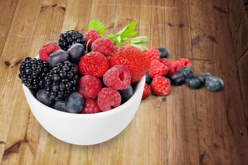 bowl of fresh tasty fruit salad on a wooden table.