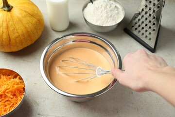 Making pumpkin pancakes. Woman mixing dough at light table, closeup