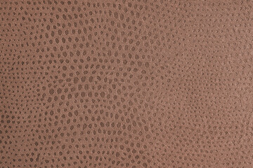 Cloth structure of jacquard brown fabric with abstract shabby spotted embossed texture closeup, macro. Upholstery, decorative cloth structure, home decor canvas. Background, backdrop, wallpaper.