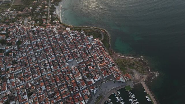 ripresa aerea dei Quartieri perfetti e regolari di una cittadina in Sardegna in Italia che si affaccia sul mare in estate durante il tramonto