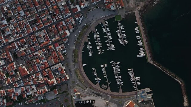 ripresa verticale aerea della cittadina e del porto di Calasetta in Sardegna in Italia durante un tramonto d'estate,.