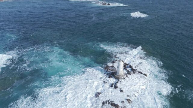 faro in mezzo mare con onde forti