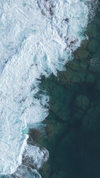 video aereo verticale in formato social di un faro in mezzo al mare durante un maremoto