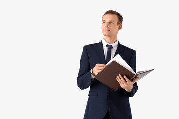 Handsome businessman in suit with notebook on white background