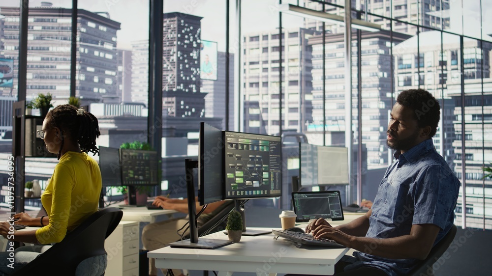 Aufkleber system administrator in office yawning during shift, feeling tired while looking at software interfa