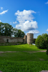 Ancient stone fortress wall and round tower under blue sky