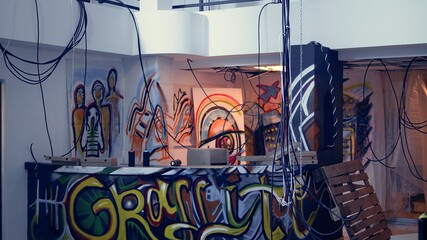 Empty industrial building with rubble and graffiti paint, concept of alternative lifestyle. Criminal hideout used by edgy teenagers to hangout and commit illegal drawing on walls, jib down and up shot