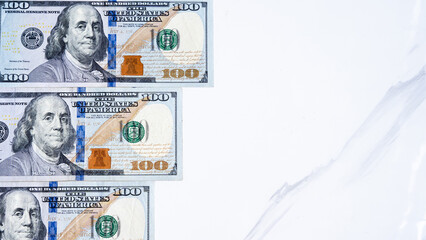 Hundred-dollar bills on a marble surface for a financial theme
