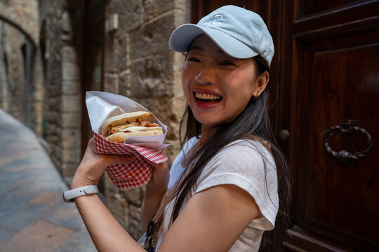 Fototapeta Woman Enjoying Local Cuisine in the Streets of Volterra