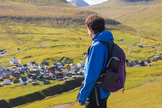 Solo traveler man up on a hill on Gjogv in the Faroe Islands