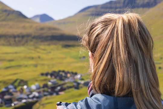 Solo traveler woman up on a hill on Gjogv in the Faroe Islands