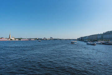 Obraz premium Wide river view with bridge and cityscape under clear blue sky