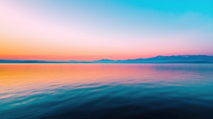 Fototapeta premium A serene seascape featuring a tranquil ocean reflecting vibrant hues of blue and pink during sunset.