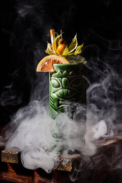 Exotic tiki cocktail with citrus and tropical garnish in smoke