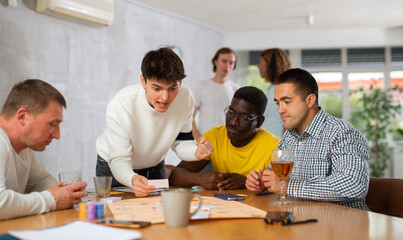 Group of active men play board games during a friendly meeting