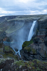 Large Waterfall in Iceland coming from cliffs, moody, foggy