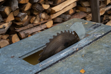 Circular saw and stack of firewood