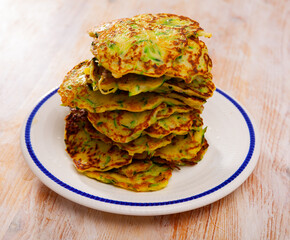 Stack of appetizing zucchini fritters on plate. Vegetarian snack....