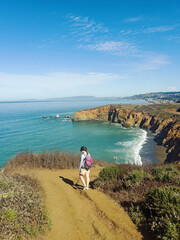 Hiker exploring coastal cliffs with ocean views in California's coastline