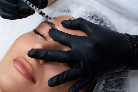 A beautician gives a woman a Botox injection. A procedure for beauty and rejuvenation.
