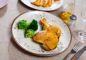 Piece of baked fried chicken is complemented with broccoli cabbage. Appetizing minimalistic snack, dish of meat and vegetables.