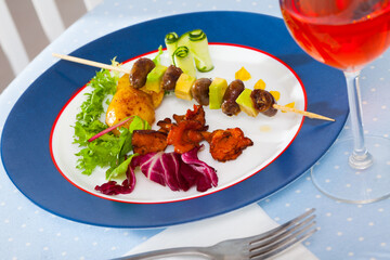 Delicious fried chicken heart skewers with avocado and fried chanterelles served at plate