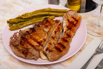 Spicy well done roasted veal steak served with asparagus