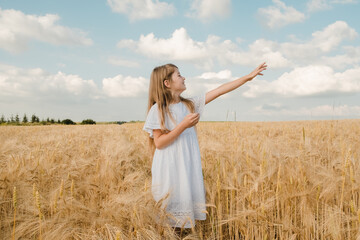 Up close portrait of happy young girl in sunny corn field.Close-up portrait of a young blonde in a golden field on a sunny summer day. Pretty blonde posing against the background of nature. Summer .