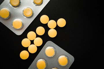 Pills Medicine tablet Brown Yellow in blister pack on a black background