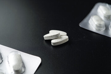 white Pills Medicine tablet capsules in blister pack on a black background