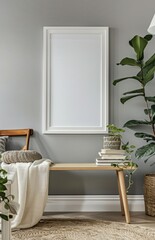 A large white frame hangs on a light gray wall with a wooden bench in front of it and a large plant on each side There is a rug on the floor and a few items on the bench including a blanket and a stac