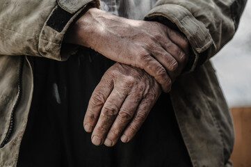 Man's hands in machine motor oil.