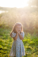 A cute little girl posing in a city park on a sunny day. Perfect for themes of childhood, innocence, and joy, capturing the essence of playful youth in a vibrant urban setting.Beautiful girl posing in