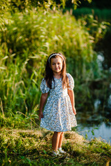 Happy smiling kid enjoying vacation in park.Adorable little girl picking the first grass of spring.Adorable little girl picking the first flowers of spring in the woods on beautiful sunny spring day.