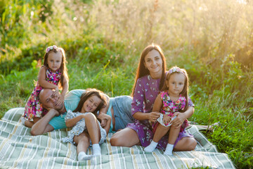 Family picnicking in the park.Family on nature vacation.The loving family is on a picnic. The mother, dad and two kids are sittinng on a blanket in the lavendder field on sunset.