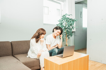 部屋にいる男女（ノートパソコン・困る）
