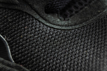 Close-up of textured black shoe fabric in a subtle background showcasing craftsmanship and design detail