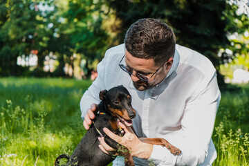 Travel in nature with your dog. Active healthy lifestyle, tourism. Pet, human.Guy hand strokes dog, hostess loves pet. Smile, Muzzle of dog. Walking with an outdoor puppy. Caress, stroke dog.
