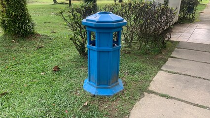 A blue trash can is placed in the playground area.