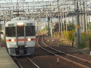 Fototapeta premium 昼の愛知県稲沢市のJR駅の線路と電車の風景